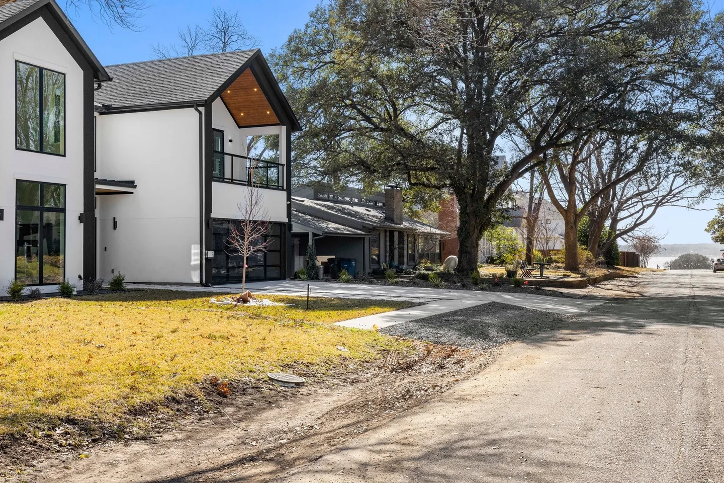 A quiet residential street in East Dallas lined with mature trees and single-storey houses.